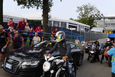 Lewis Hamilton arrives on a motorcycle