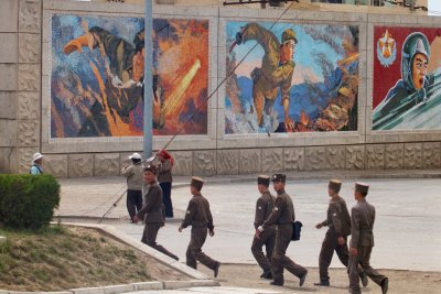 Soldiers under military mural
