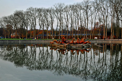 the main fountain reflects the trees and the lone statue