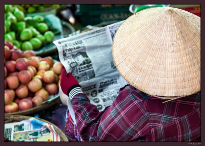 62 Reading newspaper in the market. Hue