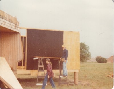 Mary and Steve putting up fiber board on the exterior kitchen wall.