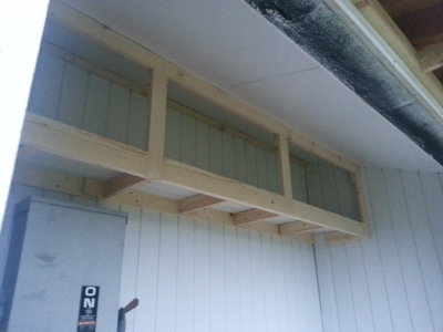 Built-in upper shelves for storage in the potting shed.
