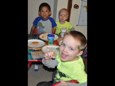 Joseph, Nathan and Luke share some pizza at the Lightning McQueen table.