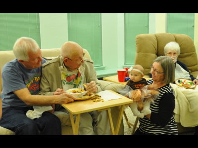Steve, Great-Grandpa and Great-Grandma look on while Grandma Kathy presents baby Ruthie in her Thanksgiving ensemble.