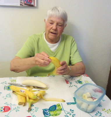 Jackie is practicing peeling bananas the way the monkeys do, according to Leslie.