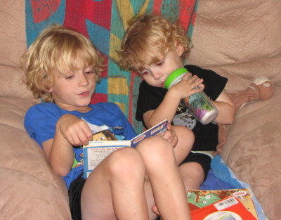 Big brother reads to his little brother.