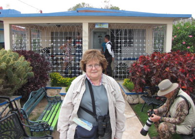 Mary enjoys the landscaping at Hostal Luis while Bob checks his hummingbird egg photos.
