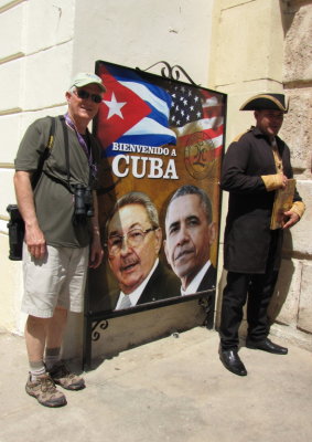 Steve and the cryer bracketing the poster of Castro and Obama