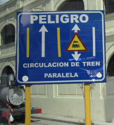 I saw several railroad warning signs like this while we were bussing around Cuba.
I thought it was interesting that the symbol used is an old steam locomotive.
This one is in front of a display of old locomotives outside the public market.