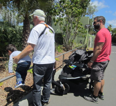 Grandpa helps Zeke get a closer look at something while Dad looks on.