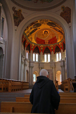 A Monk in  Prayer with the  Sun over the Dome