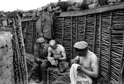 Soldiers picking lice from their clothes