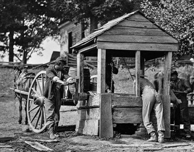 1864 - Union soldiers drawing water from a well to fill their water cart