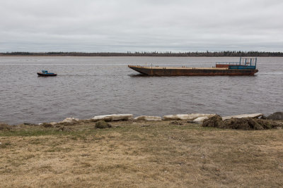 Tug brings a barge downstream to anchorage in Moosonee 2013 May 22nd.