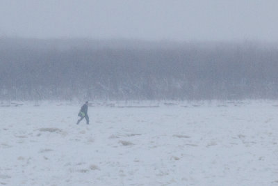 Man walking towards Moosonee on the Moose River 2013 November 30th.