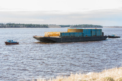 Small tugs bring barge down the river from winter storage May 22nd.