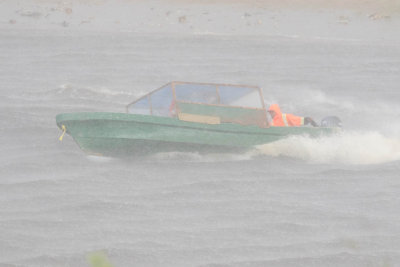 Taxi boat turning during heavy rain.