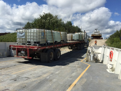 Innes Transport truck and trailer back onto barge Niska I in Moosonee.