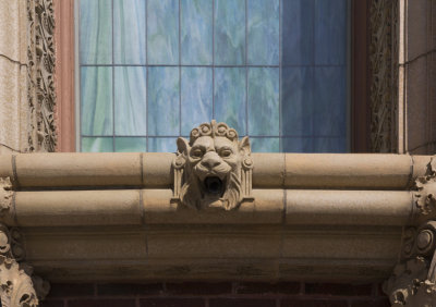 Lion terra cotta ornament below stained glass windows