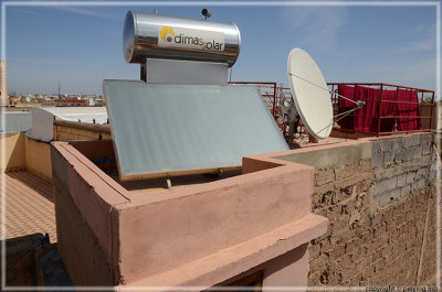Old and New: solar heater, satellite dish, drying of freshly dyed fabric