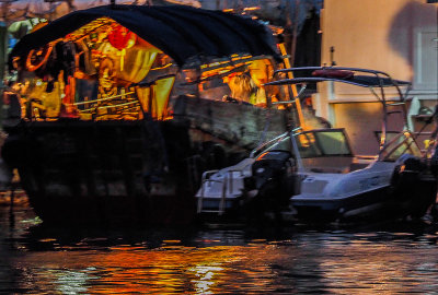 As in an Indonesian Wayang shadow puppet show,the projected  image of a sampan fisherman mending his nets