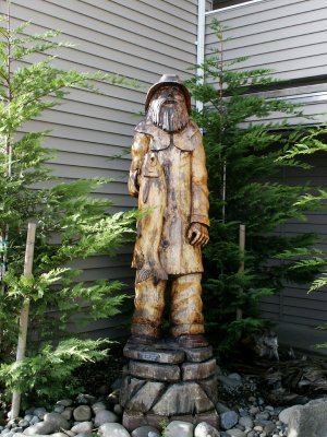 Wood fisherman in rain gear sculpture