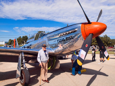 A WW 11 vet posing with a  P-51 Mustang.