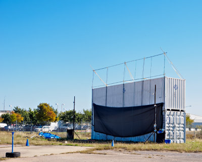 The screen. It appears to be constructed from shipping containers