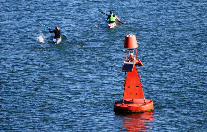 Paddlers past the port marker buoy