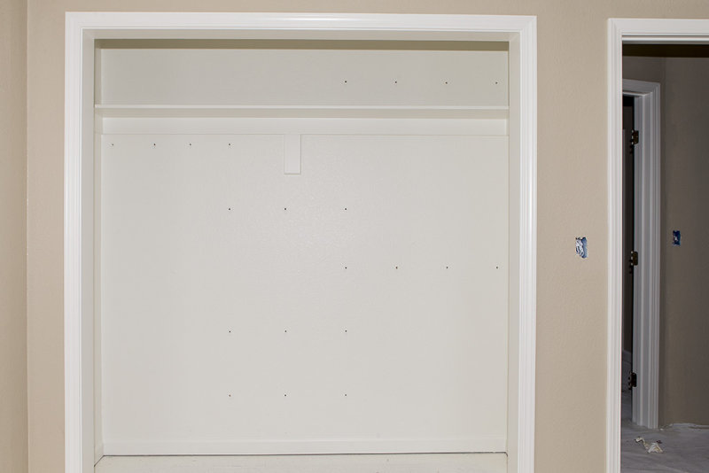Wire shelf brackets removed from closet wall