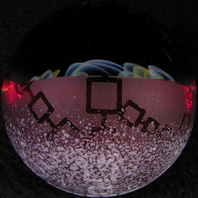 The backside has raised white frit over a red base, with geometric patterns etched and molded into it.