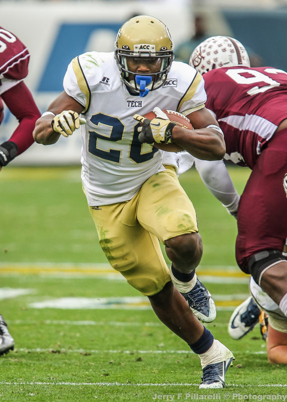 Yellow Jackets BB Sims runs through a hole in the line