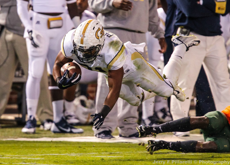 Yellow Jackets A-back dives over a Hurricanes defender