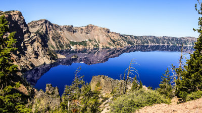 The lake rim reflected in calm waters in Crater Lake National Park