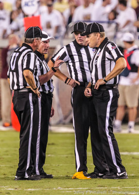 Game officials discuss the repercussions of the flag thrown on the play
