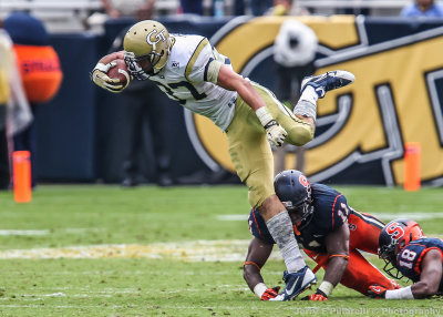 Yellow Jackets RB Zach Laskey steps over several Orange defenders