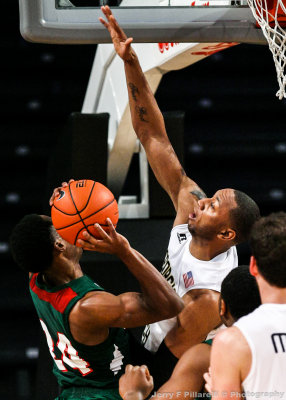 Jackets F Kammeon Holsey goes up to block the shot of Delta Devils G Anthony McDonald