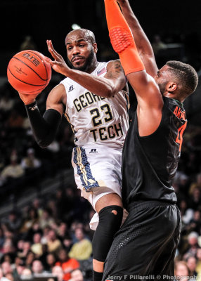 Georgia Tech G Trae Golden passes as he runs into Miami F Raphael Akpejiori