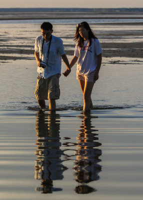 A couple reflected in the water at Rock Harbor on Cape Cod