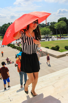 A Lincoln Memorial fan shields herself from the sun in Washington DC