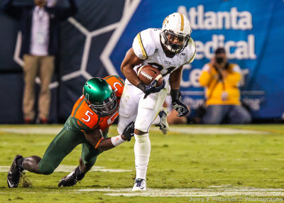 Yellow Jackets A-back Charles Perkins escapes Miami LB Jermaine Grace