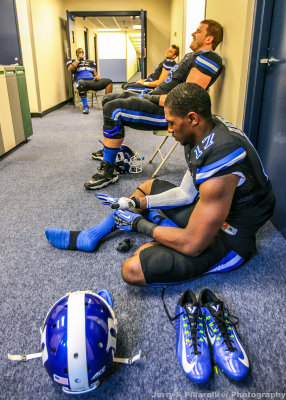 Blue Devils WR Issac Blakeney sits in a hallway with teammates during the weather delay