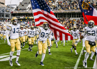Jackets DL Antonio Simmons carries the flag onto the field prior to the game