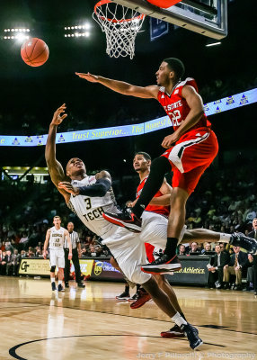 Jackets F Georges-Hunt flips the ball over Wolfpack G Turner as he goes to the floor
