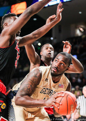 Yellow Jackets C Demarco Cox is trapped on the baseline by Louisville defenders