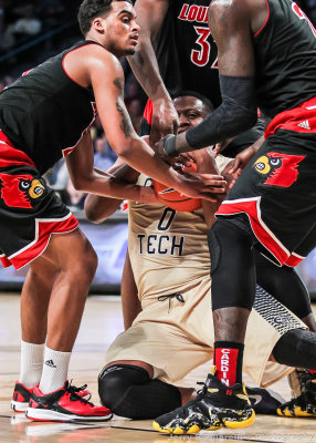 Jackets F Mitchell is trapped by Louisville defenders