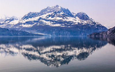 Calm waters reflect a mountain range in Glacier Bay National Park