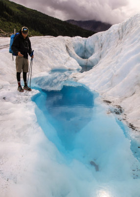 Our guide Hunter next to a blue pool on Root Glacier in Wrangell-St Elias National Park