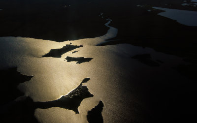 The midnight sun reflects off of a body of water north of the Arctic Circle