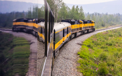 The Alaska Railroad train passing through the smoky Alaskan wilderness